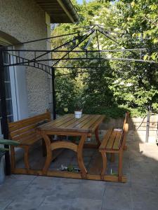 - une table de pique-nique en bois et un banc sur la terrasse dans l'établissement Chez madame loic, à Fère-Champenoise
