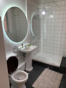 a bathroom with a toilet and a sink and a mirror at Luxury Valletta Apartment in Valletta