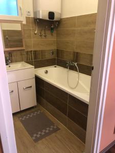 een badkamer met een bad en een wastafel bij Frankie Holiday Apartment I. in Balatongyörök