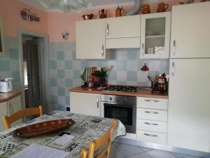 Una cocina con una mesa y un refrigerador blanco. en Mare, Monti e...Cinque Terre, en La Spezia