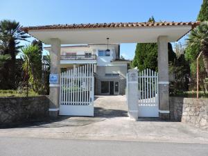 a white gate in front of a house at Albergue Pallanes in Tui