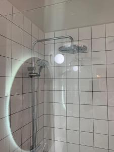 een douche met een ronde spiegel op een betegelde muur bij Luxury Valletta Apartment in Valletta