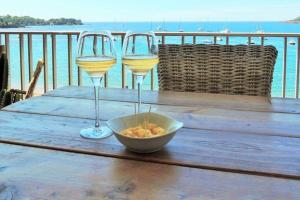 a table with two glasses of wine and a bowl of food at emplacement privilégié pour ce bel appartement in Agay - Saint Raphael