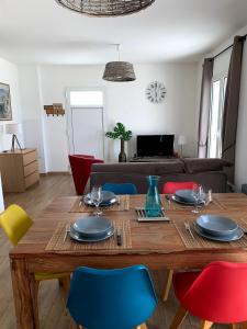 ein Esszimmer mit einem Holztisch und bunten Stühlen in der Unterkunft Appartements Résidence Casa Toga in Galeria