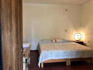 1 dormitorio con 1 cama y 1 lámpara en una mesa en Posada Teopanco, en Tepoztlán