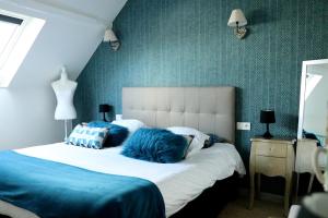 a bedroom with a white bed with blue pillows at Ilot Désille in Boulogne-sur-Mer