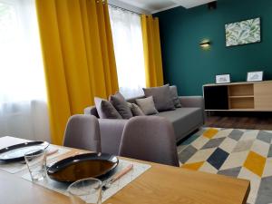 uma sala de estar com um sofá e uma mesa em Emerald Apartament em Bialystok