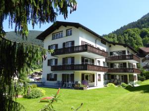 ein großes weißes Gebäude mit Balkonen auf einem grünen Rasen in der Unterkunft Apartments Trepp in Klosters