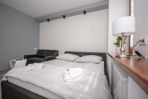 a bedroom with a bed with two white towels on it at Apartamenty AP 11 in Częstochowa