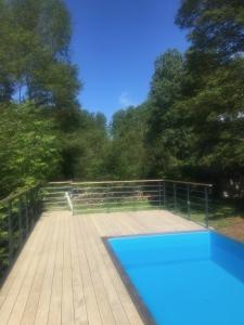 - une piscine sur une terrasse en bois avec des arbres dans l'établissement Domaine de La Clef des Champs, à Limeray