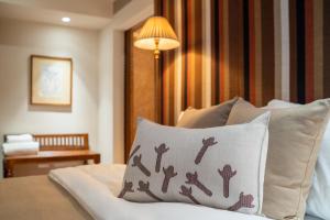 a room with a bed with a pillow and a lamp at Cinnamon Bentota Beach - Signature Selection in Bentota