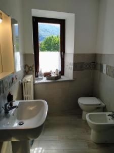 La salle de bains est pourvue d'un lavabo, de toilettes et d'une fenêtre. dans l'établissement Chez Bonjour, à Villar Pellice