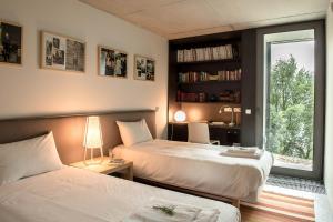 a bedroom with two beds and a window and a desk at Villa Covela in Baião