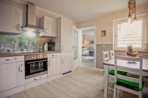 a kitchen with white cabinets and a counter and a table at Kleine Auszeit in Bad Segeberg