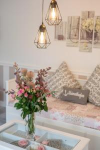 un jarrón de flores sobre una mesa de cristal con una cama en Kleine Auszeit, en Bad Segeberg