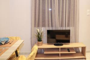 a living room with a television on a table at Chrissomallis Apartments in Skiathos