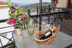 una mesa con una cesta y flores en el balcón en Chrissomallis Apartments, en Skiathos