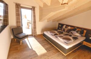 um quarto com uma cama e uma cadeira em Die Gipfelresidenz - Hinterthal em Maria Alm am Steinernen Meer