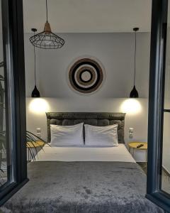 een slaapkamer met een groot bed met witte kussens bij Elements Studios in Néa Péramos