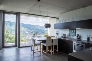 a kitchen with a table and chairs with a view at Villa Covela in Baião