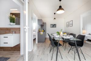 a dining room and kitchen with a table and chairs at New Wave Resort Mielno in Mielno