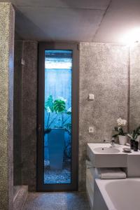 a bathroom with a glass door with a potted plant at Villa Covela in Baião