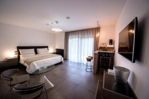 Aminta Resort في Genazzano: غرفة نوم بسرير وطاولة وكراسي