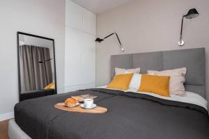 Un dormitorio con una cama con una bandeja de comida. en Stylish Apartment Luminis in Krakow's Kazimierz, en Cracovia