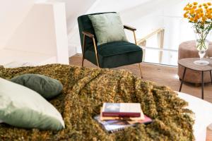 sala de estar con sofá y silla verde en Haus im Schlossergässchen, en Baden