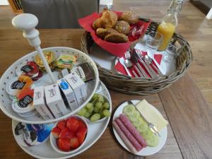 einen Tisch mit 2 Tellern und einem Korb mit Lebensmitteln in der Unterkunft B&B Onder de rode beuk in Dieren