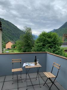 2 sillas y una mesa en un balcón con montañas en Grotto Pergola, en Giornico