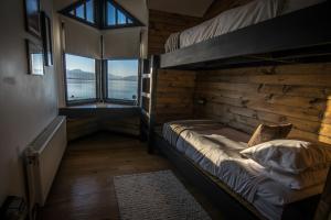 a room with two bunk beds and a window at Kau Lodge in Puerto Natales