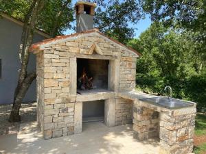 a stone pizza oven with a fire in it at Apartment Mrgani 1814 in Mrgani