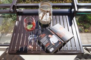 a book and a glass of wine on a bench at Haus am See in Storkow
