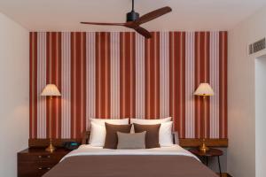 a bedroom with a bed and a striped wall at Cinnamon Bentota Beach - Signature Selection in Bentota