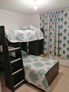 מיטה או מיטות קומותיים בחדר ב-Departamento centrico cerca de la feria