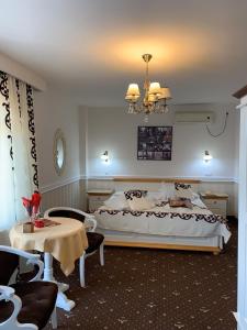 a bedroom with a large bed and a chandelier at Pensiunea Casa Simoni in Ploieşti