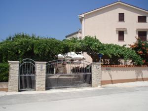 a gate in front of a building next to a house at Haus Milan AP 1 in Fažana