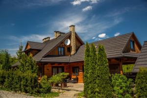 a wooden house with a gambrel roof at Agroturystyka Barnilka in Klimkówka