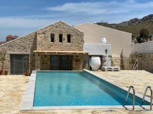 a house with a swimming pool in front of a house at LAINI LUXURY SUITES in Pómbia