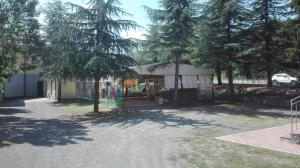 un edificio con parque infantil en un patio con árboles en Ostello di Montefiorino en Montefiorino