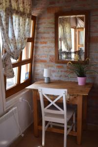 drewniany stół i krzesło w pokoju z oknem w obiekcie Remete-lak w mieście Villány