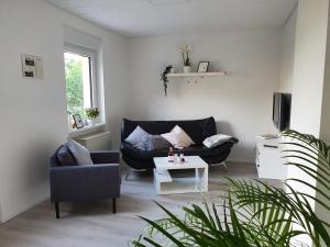un soggiorno con divano nero e tavolo di Ferienhaus Calmont a Bremm