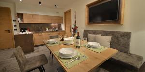 a dining room with a wooden table and a kitchen at Roberta Loft - rooms and apartments in Livigno