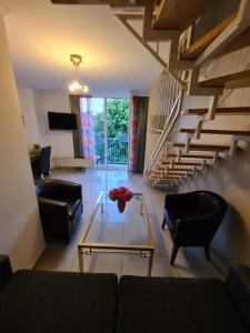 a living room with a couch and a table and stairs at Hotel Cara Vita Cologne in Cologne