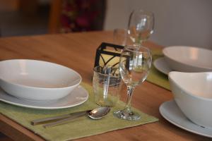 una mesa con platos, tazones y copas de vino en Roberta Loft - rooms and apartments en Livigno