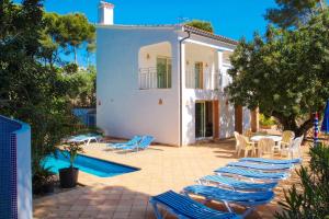 モライラにあるEl Pinar - sea view villa with private pool in Morairaの一組の椅子と一軒家のあるスイミングプール