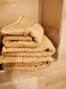 a stack of towels sitting on a shelf in a bathroom at Enklawa Mielno przy plaży in Mielno