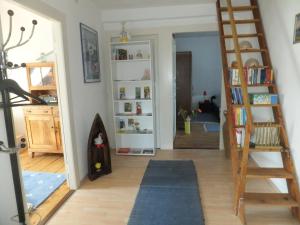 a room with a staircase and a book shelf at Ferienwohnung im Zentrum in Radolfzell am Bodensee