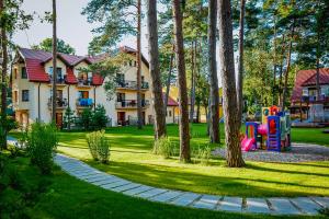 a park with a playground in front of a house at Ośrodek Vega in Pobierowo